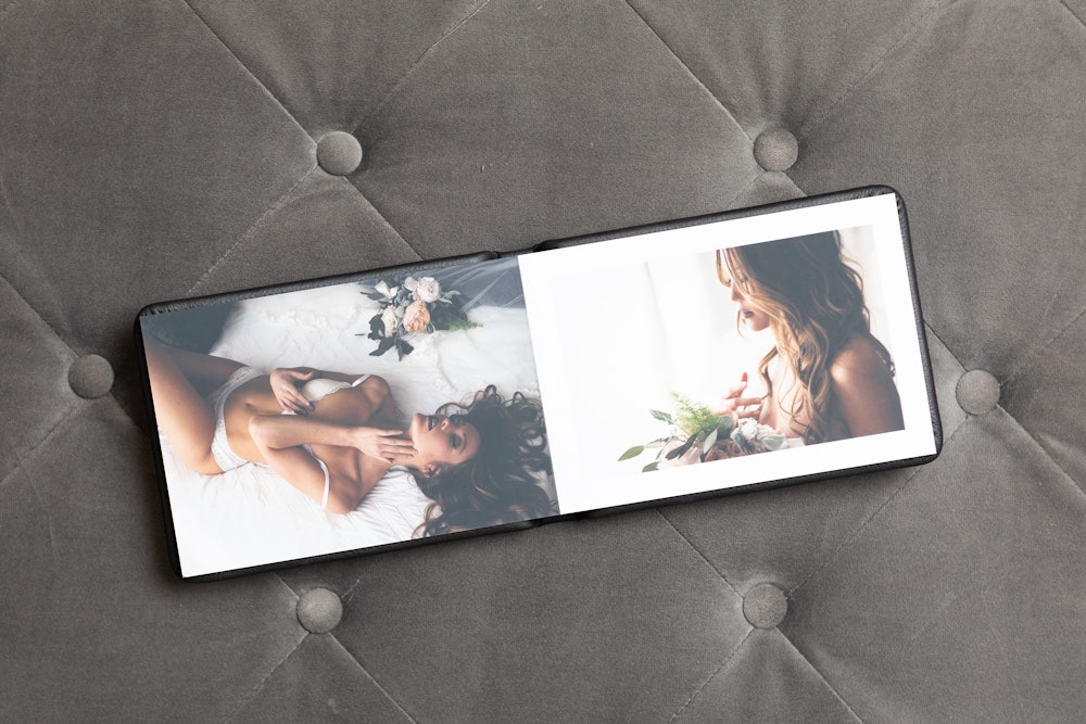 Boudoir Album open on a gray tufted fabric