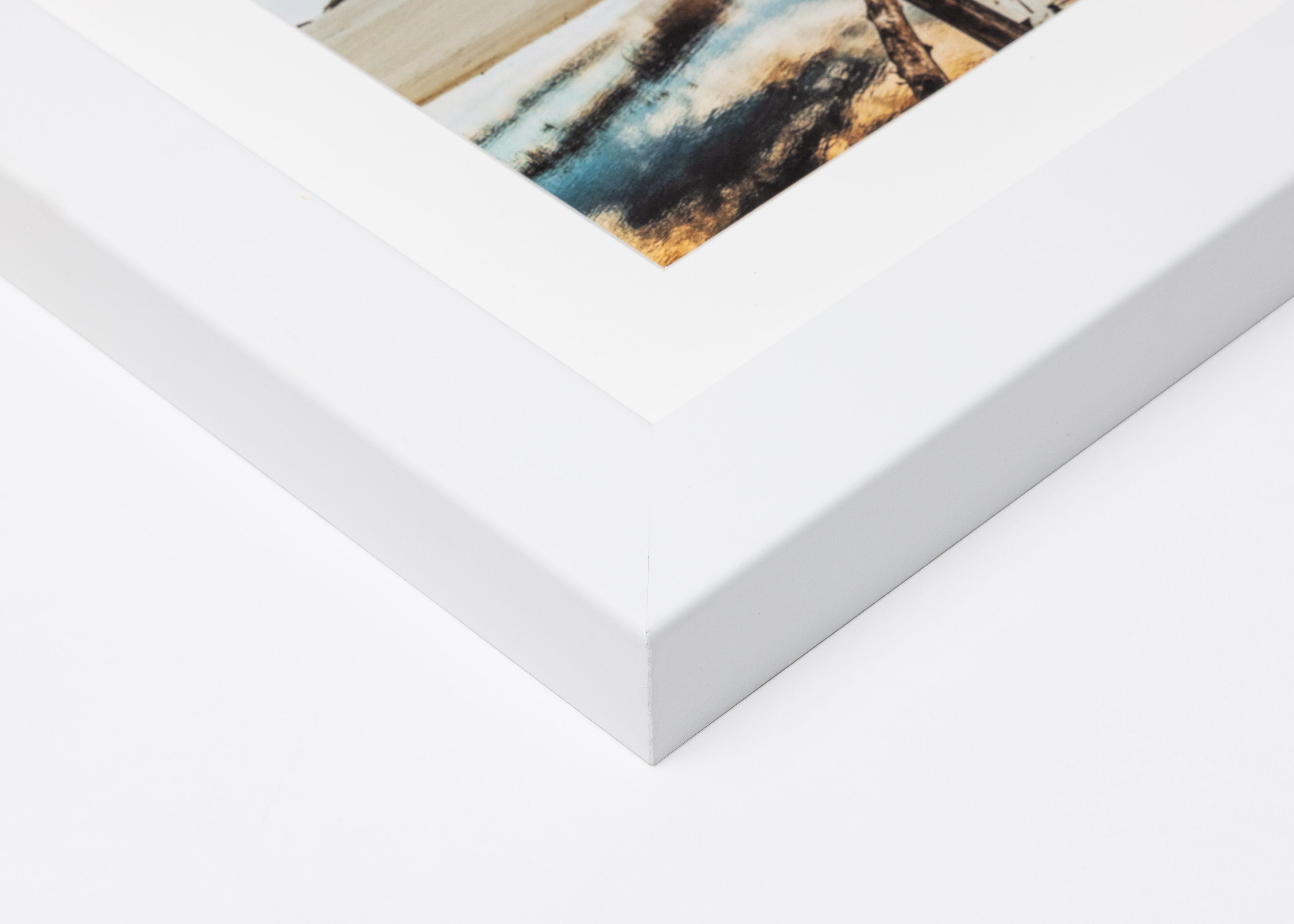 Close-up corner of a White Gallery Framed Print moulding on a white background