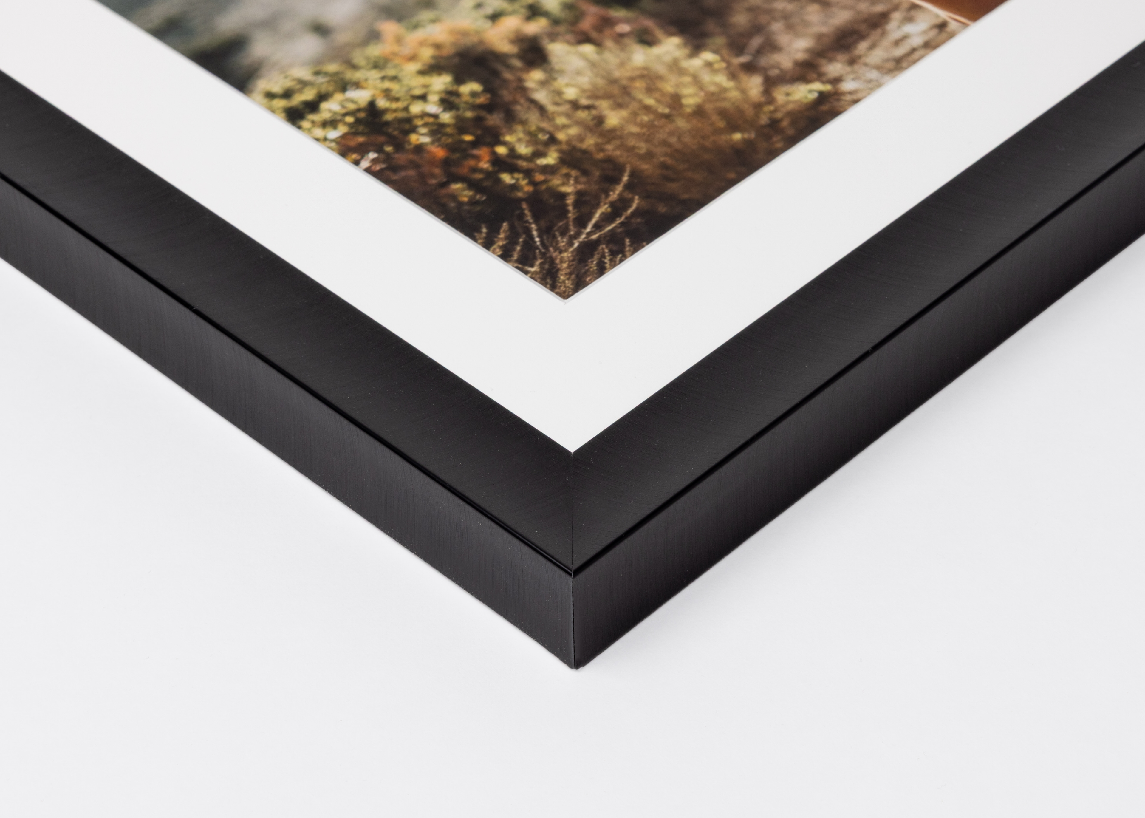 Close-up corner of a Jet Black Metal Framed Print moulding on a white background