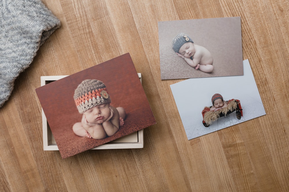 Newborn Wood Box with prints on wood tabletop