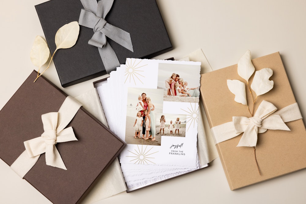 Brown, Charcoal, and Kraft Premium Packaging box covers, one open, holding Flat Cards with a holiday foil-pressed design on a cream background.