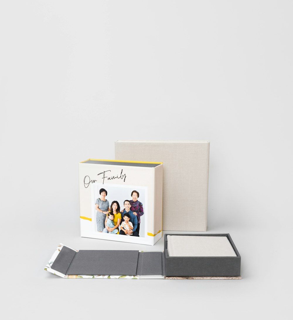 Multiple 4-panel Album Boxes, one open flat with album inside