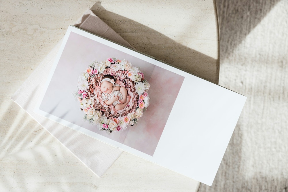 A Baby Photo Album laying open on a table.