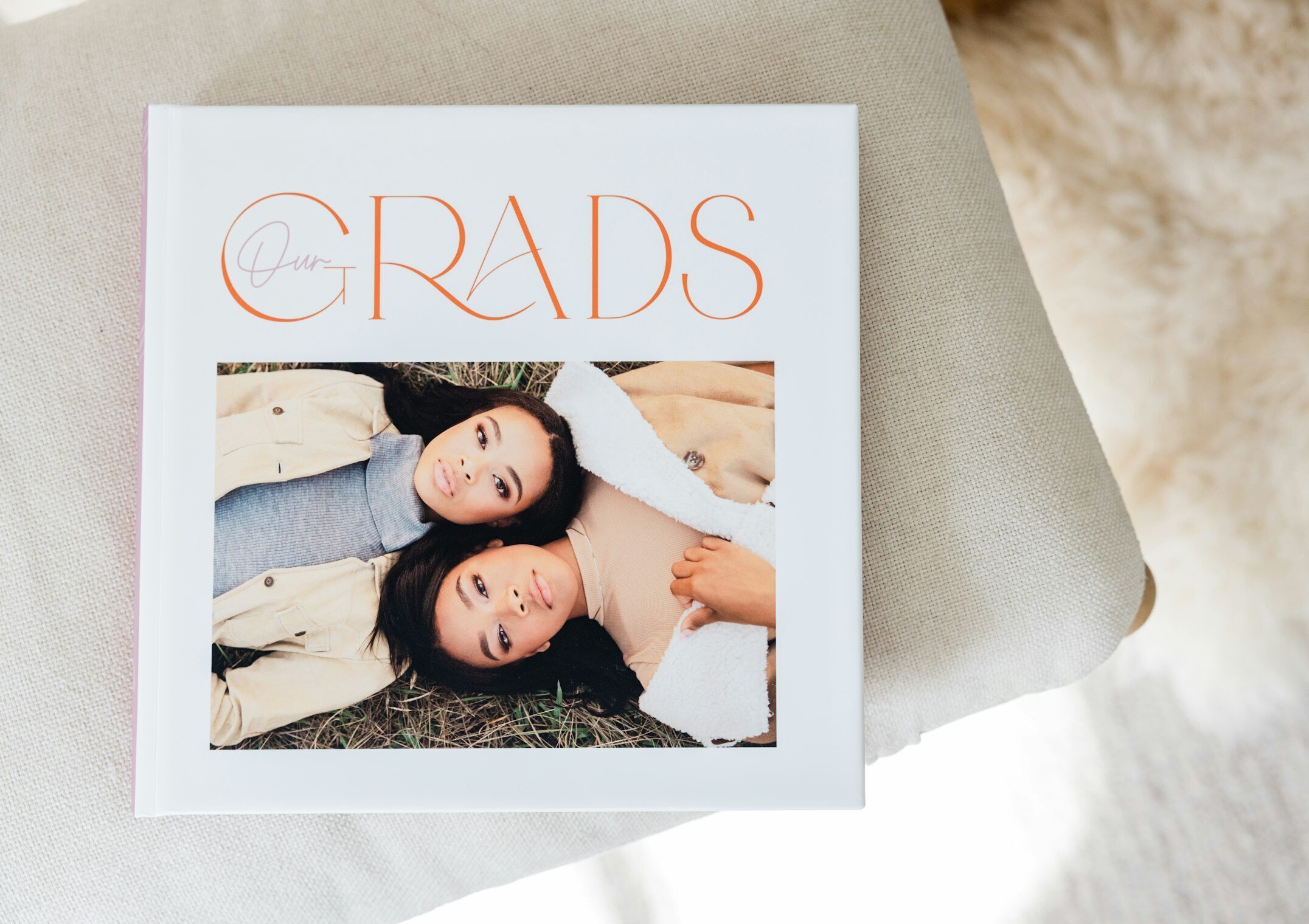 A 10x10 WHCC high school senior Photo Album with a custom photo cover laying down on a table.