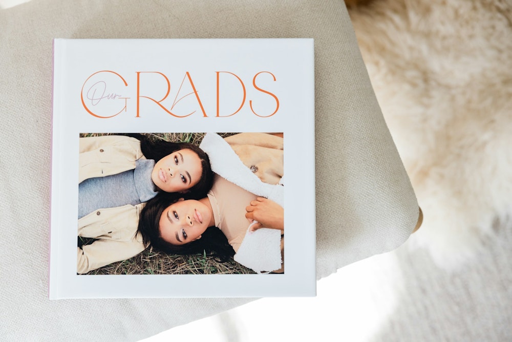 A closed 10x10 WHCC high school senior Photo Album with a photo cover laying down on a table.