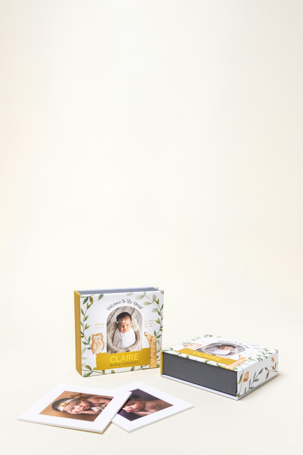 Two 4-Panel Print Boxes with custom photo covers featuring newborn photography printed on the cover and matted prints, displayed on cream background