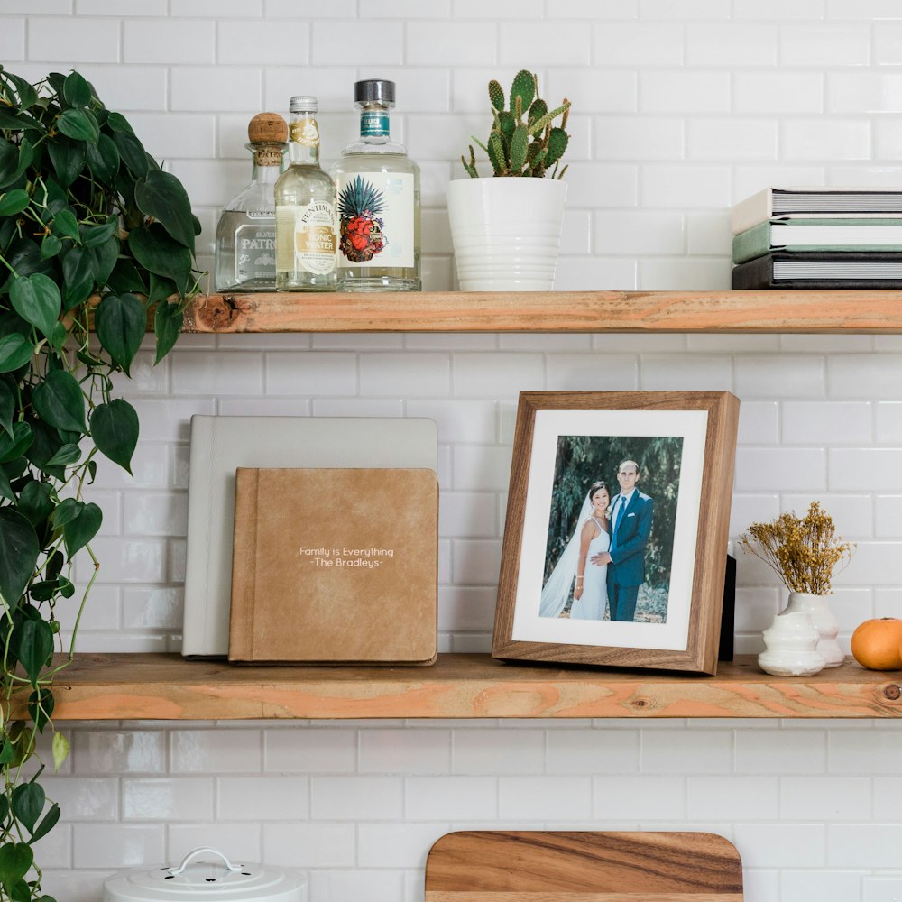 Walnut Woodland Framed Tabletop Print on kitchen shelf with leather Albums