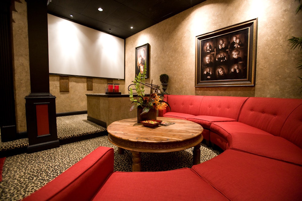 Photography studio sales room with large projector screen and red couch