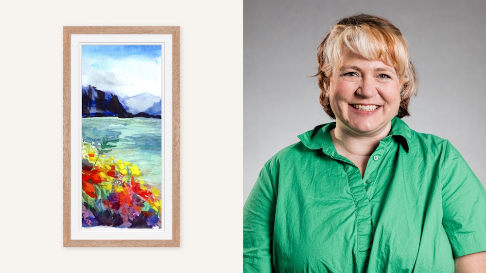A split-image showing a Woodland Framed Print of an abstract watercolor landscape painting featuring vibrant blues, greens, and yellows on the left. On the right, the artist with short blond hair, wearing a green shirt, smiles against a gray background.