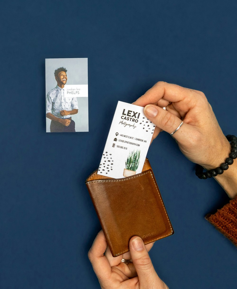 Hand placing Business Cards into wallet