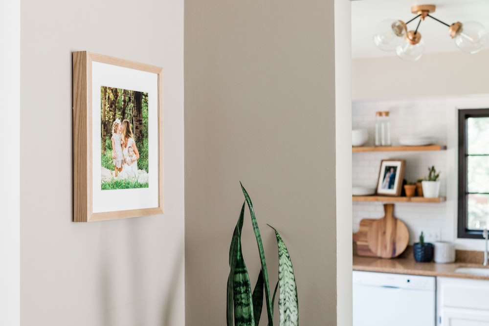 Natural Woodland Framed Print with white mat hanging in kitchen hallway